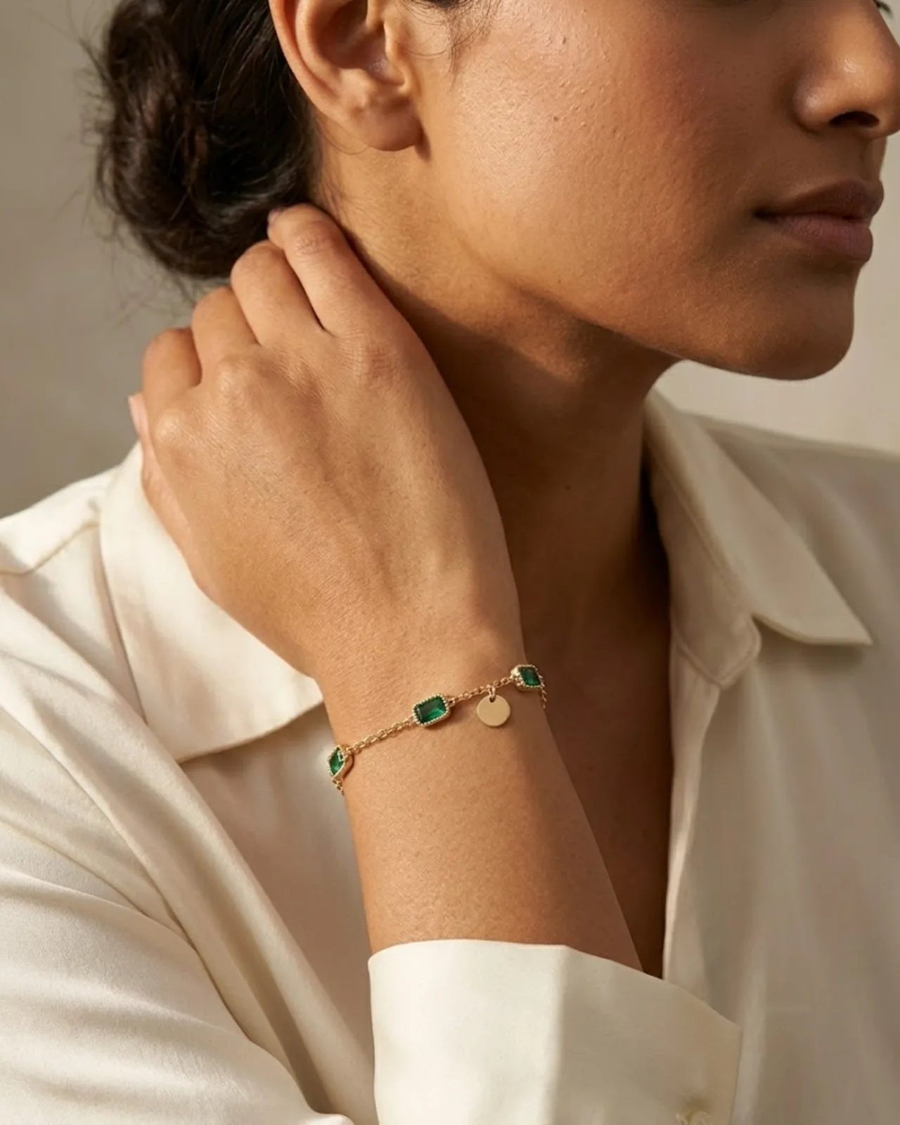 Élise Emerald Chain bracelet resting on a soft draped fabric
