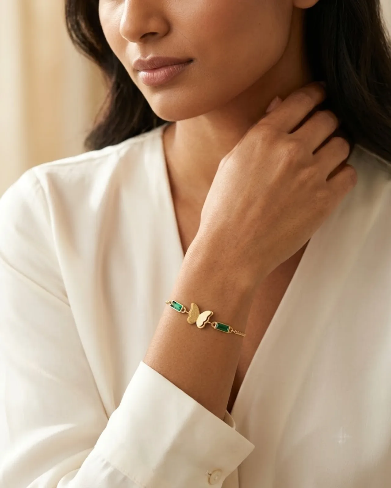 Céleste Butterfly Chain bracelet resting on a soft draped silk fabric