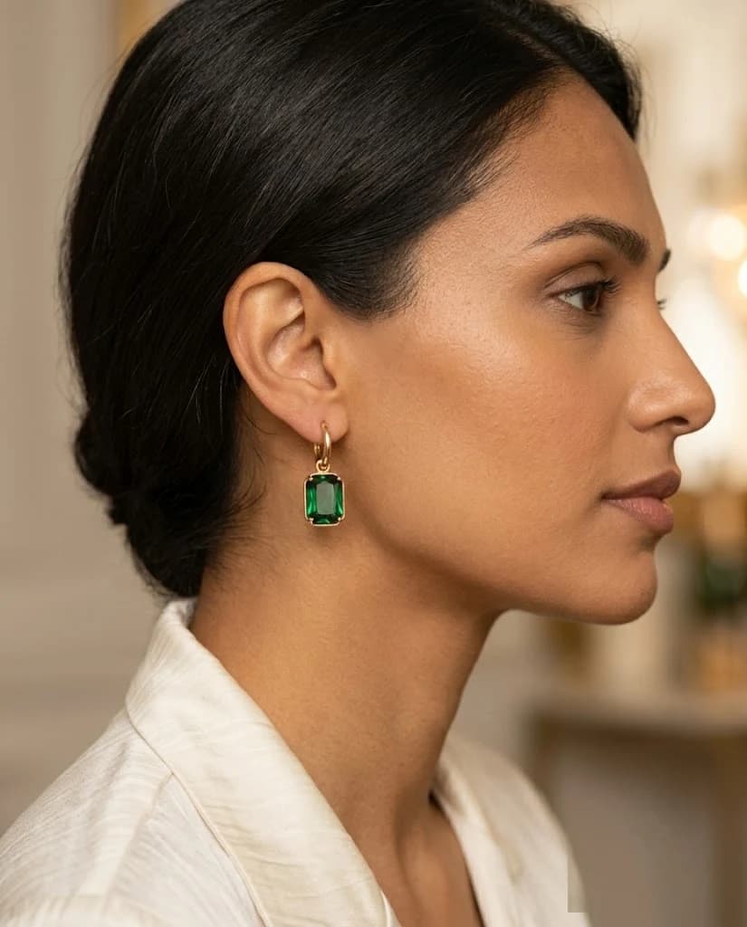 Front view of the Élise Emerald Drops featuring huggie hoops and emerald-cut stones