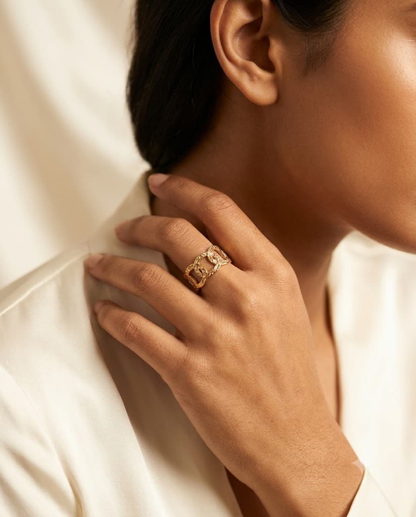 Élise Link Band ring resting on a soft, draped cream fabric background.